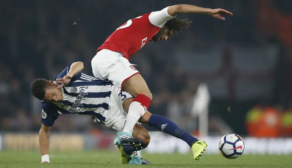 Pemain West Bromwich Albion, Kieran Gibbs (kiri) berusaha merebut bola dari kaki pemain Arsenal, Mohamed Elneny pada lanjutan Premier League di Emirates stadium, London (25/9/2017). Arsenal menang 2-0. (AP/Alastair Grant)
