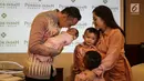 Ibas Yudhoyono mencium putrinya Gayatri Idalia Yudhoyono yang baru lahir saat jumpa pers di RS Pondok Indah, Jakarta, Selasa (2/1). Cucu keempat SBY itu lahir tepat pada 1 Januari, pukul 08.58 WIB melalui persalinan normal. (Liputan6.com/Faizal Fanani)