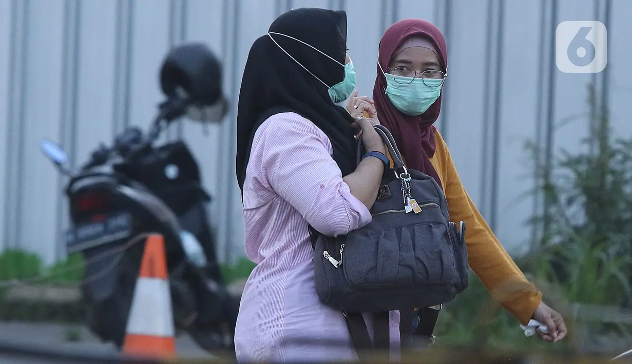 Warga mengenakan masker berjalan di Depok, Jawa Barat, Senin (2/3/2020). Dua pasien terjangkit corona yang dirawat di RSPI Sulyanti Saroso  merupakan warga Depok. Mendengar kabar yang diumumkan Presiden Jokowi membuat warga mulai mengantisipasi mengenakan masker. (Liputan6.com/Herman Zakharia)