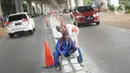 Pekerja menyelesaikan pembuatan separator atau pembatas jalan di Jalan Margasatwa, Andara, Jakarta Selatan, Kamis (21/11/2019). Separator itu dibuat guna memisahkan dua lajur sehingga meminimalisasi tingkat kecelakaan. (Liputan6.com/Immanuel Antonius)