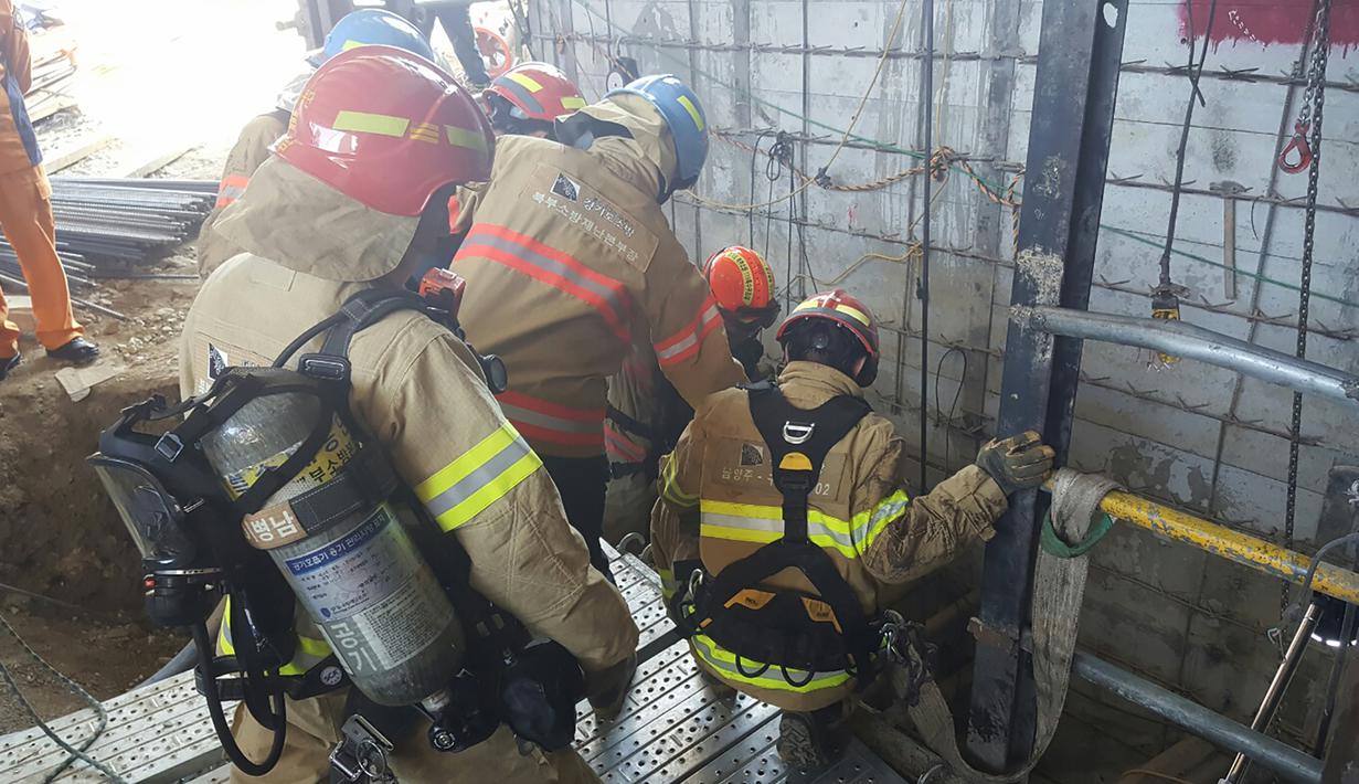 Petugas penyelamat saat akan turun ke lokasi robohnya konstruksi kereta bawah tanah di Namyangju, dekat Seoul, Korsel, Rabu (1/6). Dugaan sementara, insiden ini dipicu oleh ledakan tabung silinder oksigen di lokasi proyek. (NAMYANGJU FIRE STATION/AFP)