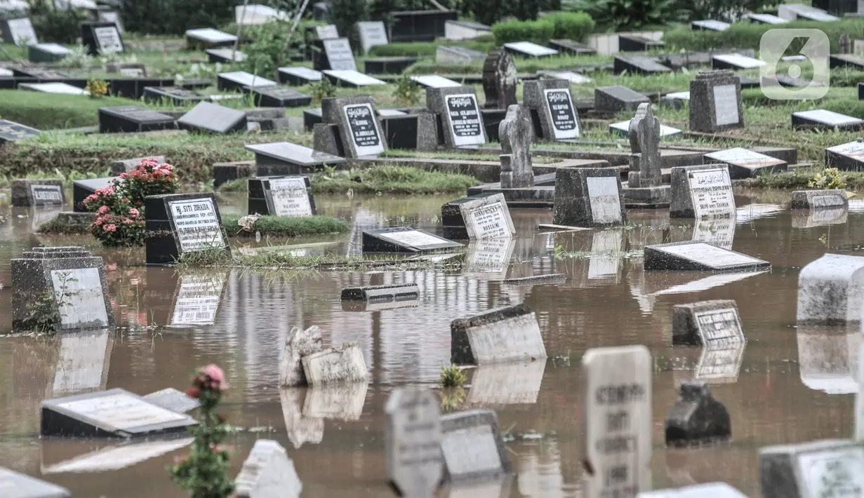 Kondisi Taman Pemakaman Umum (TPU) Karet Bivak, Jakarta, saat terendam banjir, Minggu (7/2/2021). Hujan deras yang mengguyur sejak Minggu dinihari menyebabkan tiga blok di kompleks pemakaman TPU Karet Bivak terendam banjir hingga ketinggian mencapai 30 sentimeter. (merdeka.com/Iqbal Nugroho)