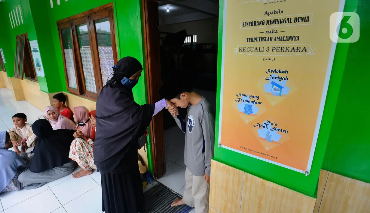 Santri baru salafiah wusto setingkat SMP angkatan pertama mencium tangan keluarganya sebelum masuk asrama pesantren di Ponpes Assalam di Kuripan, Ciseeng, Bogor, Rabu (13/7/20222). Sejumlah pesantren mulai awal bulan ini kembali melakukan kegiatan belajar mengajar Tahun Ajaran Baru 1443-1444 H/2022-2023 M. (merdeka.com/Arie Basuki)