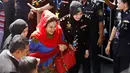 Istri mantan Perdana Menteri Malaysia Najib Razak, Rosmah Mansor dikawal petugas saat memenuhi panggilan Komisi Antikorupsi Malaysia (MACC) di Putrajaya, Selasa (6/5). Rosmah tampak tenang turun dari mobil dan berjalan ke kantor MACC. (AP/Vincent Thian)