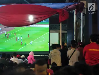 Sejumlah warga menonton pertandingan sepak bola Indonesia melawan Malaysia dalam pertandingan Sea Games 2017 di Area Kementerian Pemuda dan Olahraga, Jakarta, Sabtu (27/8). (Liputan6.com/Helmi Afandi)