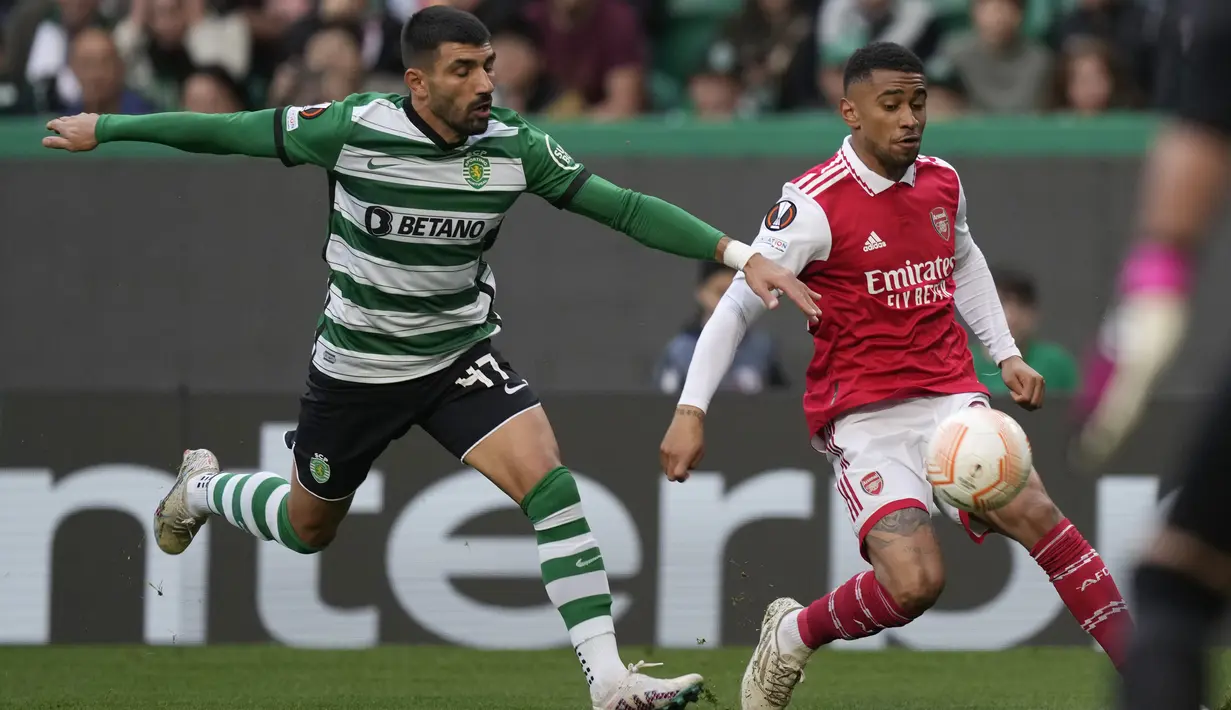 Penyerang Arsenal Reiss Nelson berebut bola dengan bek Sporting CP, Ricardo Esgaio dalam laga leg pertama babak 16 besar Liga Europa 2022-2023 di Estadio Jose Alvalade, Jumat (10/3/2023) dini hari WIB. Hasil imbang 2-2 ini berarti situasi masih sangat terbuka bagi kedua tim. (AP Photo/Armando Franca)