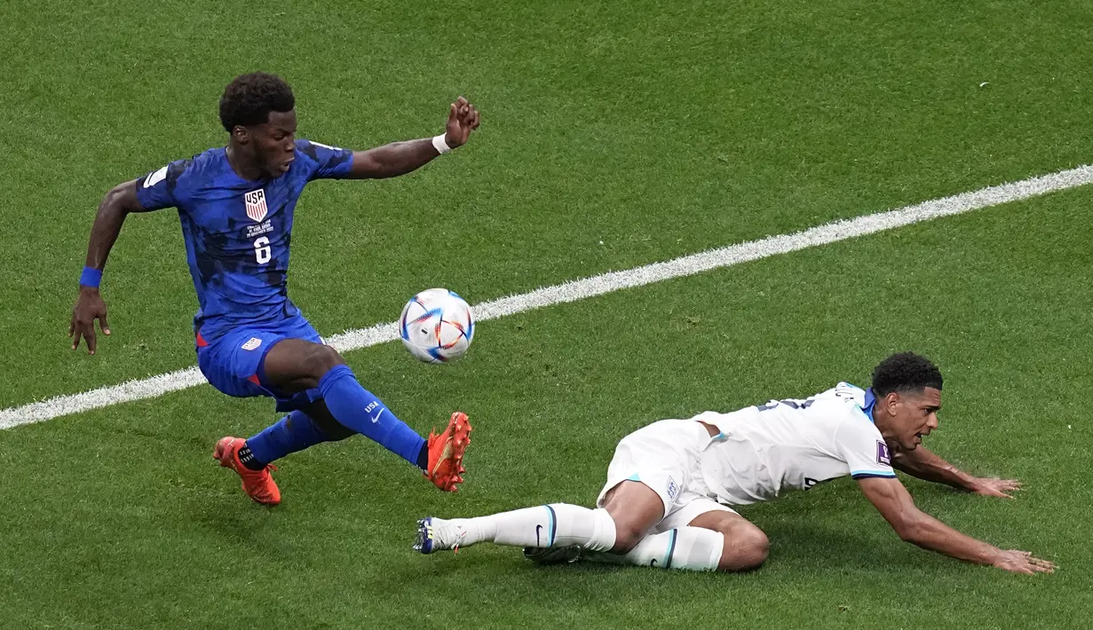 Gelandang Amerika Serikat, Yunus Musah berusaha melewati gelandang Inggris, Jude Bellingham  selama pertandingan grup B Piala Dunia 2022 Qatar di Stadion Al Bayt di Al Khor, Qatar, Sabtu (16/11/2022). Hasil ini bikin Inggris memimpin Grup B dengan empat angka. Sementara, Amerika Serikat di posisi ketiga dengan dua poin tertinggal satu angka dari Iran di posisi kedua. (AP Photo/Ebrahim Norozi)