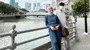 <p>Dalam foto ini, Nycta Gina berpose berdua bersama sang suami Rizky Kinos mengenakan jumpsuit bernuansa biru. Ia padukan outfit kasualnya dengan hijab pashmina berwarna abu-abu dan sneakers putih. Foto: Instagram.</p>