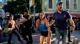 Petugas polisi anti huru hara berusaha menghalangi peserta pawai masuk ke lokasi parade Gay Pride di Istiklal Street Turki, pusat kota Istanbul, bertepatan dengan hari raya Idul Fitri 1438 Hijriah, Minggu (25/6). (YASIN AKGUL/AFP)