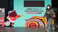 Seorang wartawan melewati papan elektronik hitung mundur yang terletak di GBK Arena, Senayan, Jakarta, Kamis (30/03/2023) sebagai respon pembatalan Indonesia sebagai tuan rumah Piala Dunia U-20 2023 oleh FIFA. (Bola.com/Bagaskara Lazuardi)