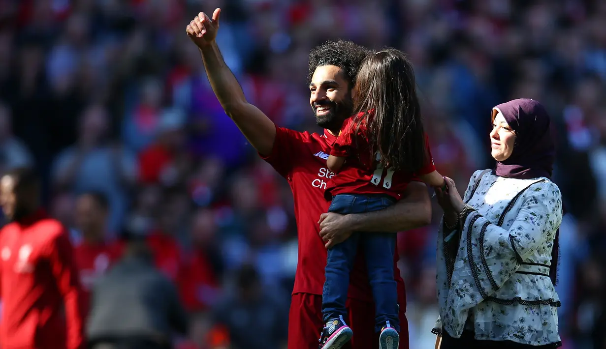 Pemain Liverpool Mohamed Salah menggendong putrinya Makka didampingi istrinya Maggi menyapa para suporter usai laga Liga Inggris menghadapi Wolverhampton Wanderers di di Stadion Anfield, Liverpool, Inggris, Minggu (12/5/2019). Liverpool gagal meraih gelar juara Liga Inggris. (AP Photo/Dave Thompson)