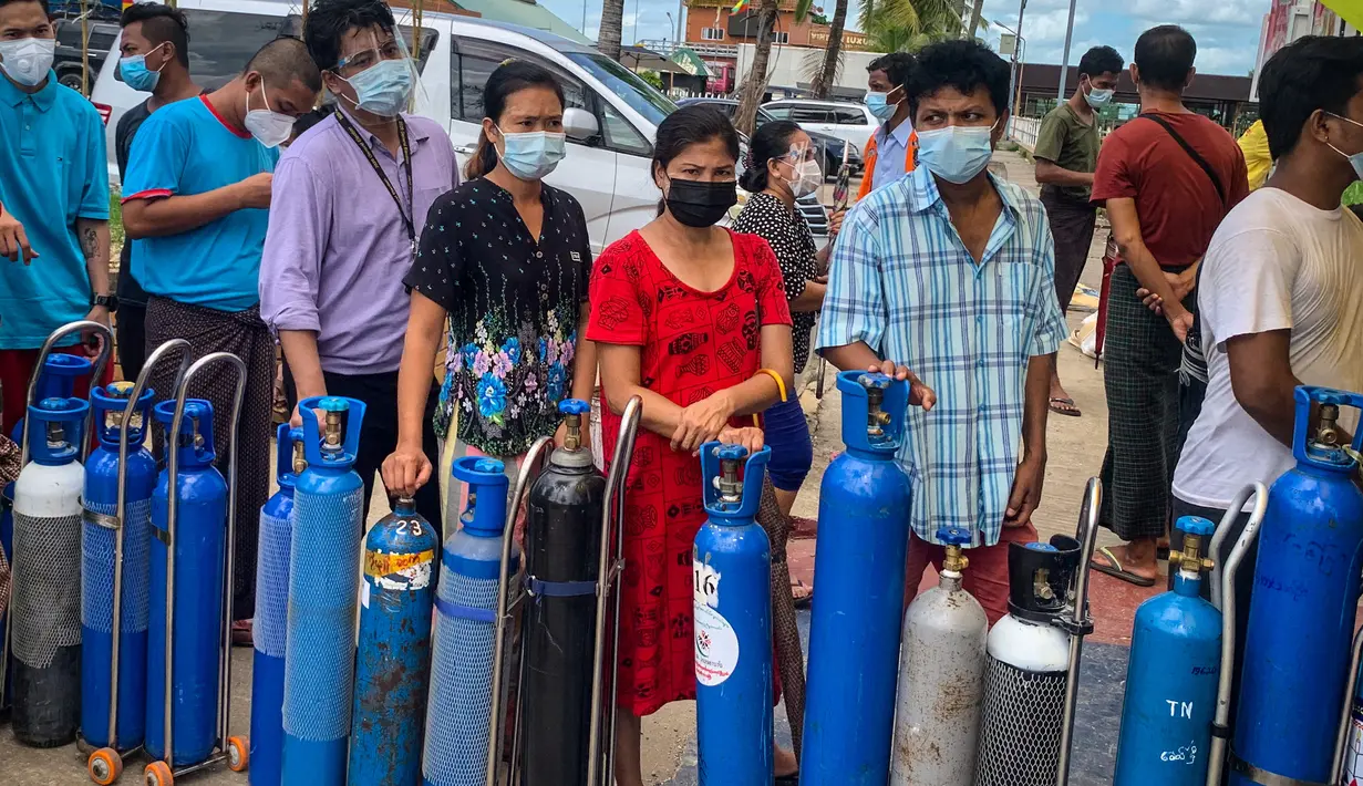 Orang-orang antre menunggu di lokasi yang menyumbangkan oksigen secara gratis di Yangon, Myanmar pada 14 Juli 2021. Mereka putus asa mencari oksigen untuk menjaga orang yang dicintai tetap bernapas ketika gelombang corona covid-19 menerjang negara yang dilanda kudeta itu. (Ye Aung THU/AFP)