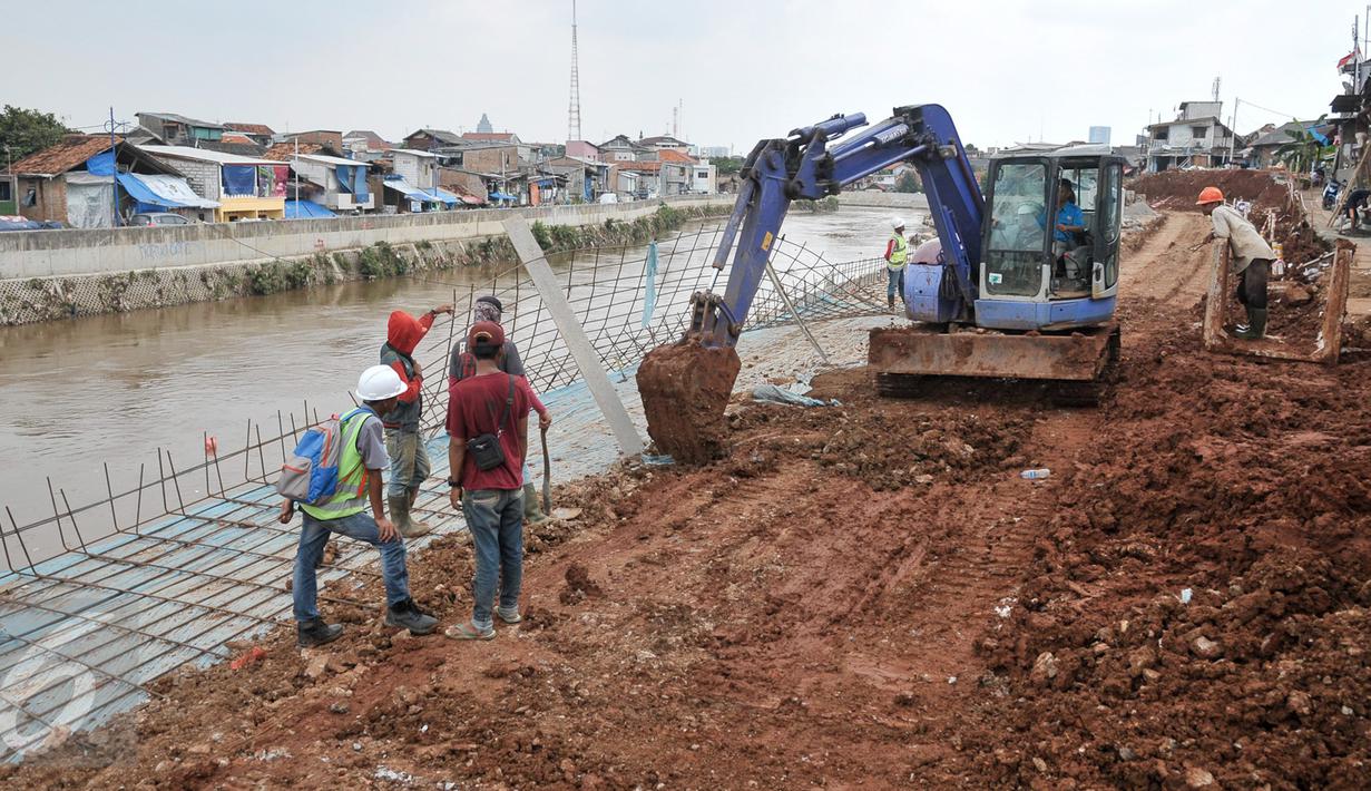 Pekerja menyelesaikan pengerjaan jalan di lokasi normalisasi sungai Ciliwung, Jakarta, Selasa (27/2). Proses normalisasi Sungai Ciliwung kembali dilanjutkan setelah terhenti karena meningginya air. (Liputan6.com/Yoppy Renato)