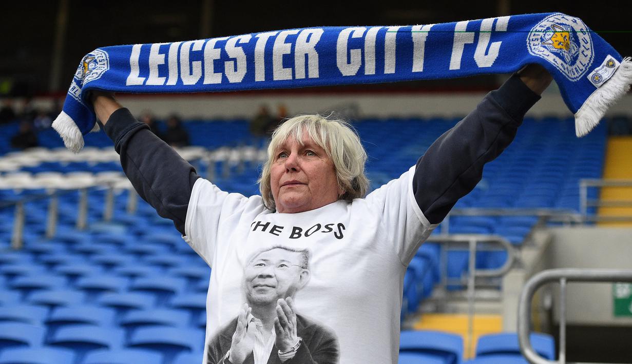 Seorang fans memakai baju bergambar Vichai Srivaddhanaprabha saat Leicester melawan Cardiff pada laga Premier League di Stadion Cardiff City, Wales, Sabtu (3/11). Pemilik Leicester meninggal akibat kecelakaan helikopter. (AFP/Oli Scarff)