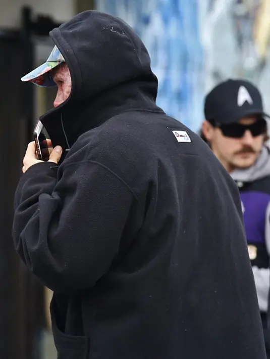 Aktor Hollywood Ryan Reynolds berjalan dengan menutupi mukanya yang tertutup make up seperti luka terbakar untuk melakukan syuting  "Deadpool". Aktor 39 tahun ini memerankan wajah Wade Wilson dalam filmnya tersebut. (Dailymail)