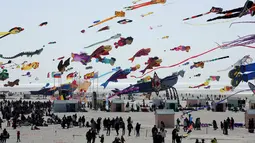 Pengunjung menyaksikan layang-layang terbang selama Festival Layang-layang Internasional ke-31 di Berck, Prancis, (6/4). Festival ini diselenggarakan di Berck-sur-Mer setiap bulan April dan berlangsung selama 10 hari. (AP Photo / Thibault Camus)