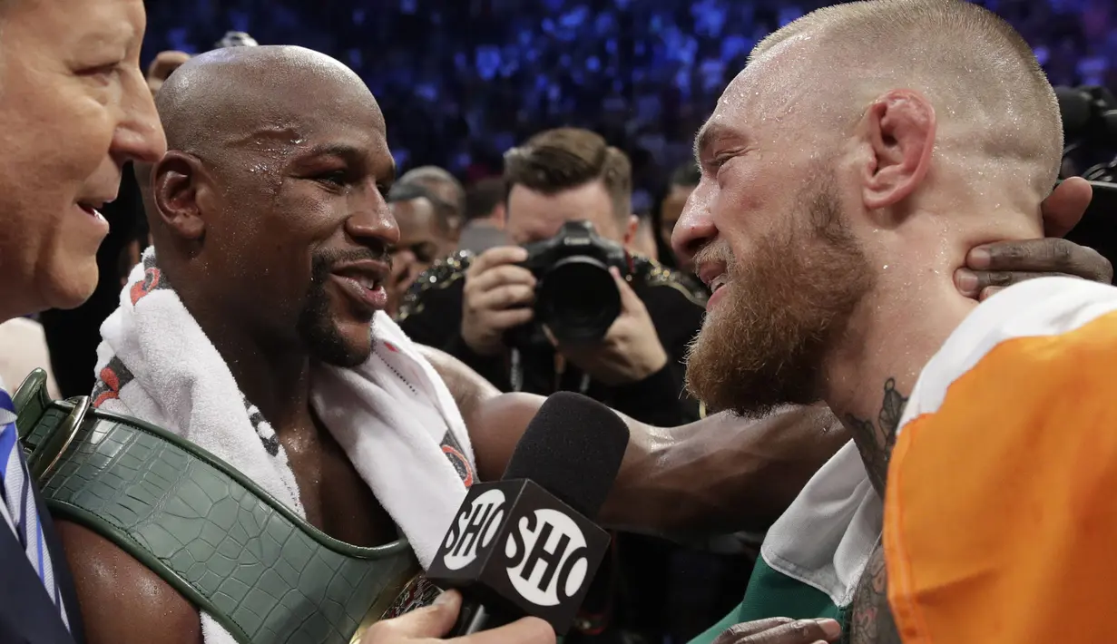 Floyd Mayweather Jr.(kiri) saat berbincang dengan Conor McGregor usai bertrung pada gelaran Tinju Dunia super welterweight boxing di MGM Arena, Las Vegas, (26/8/2017). Mayweather menang TKO atas McGregor. (AP/Isaac Brekken)