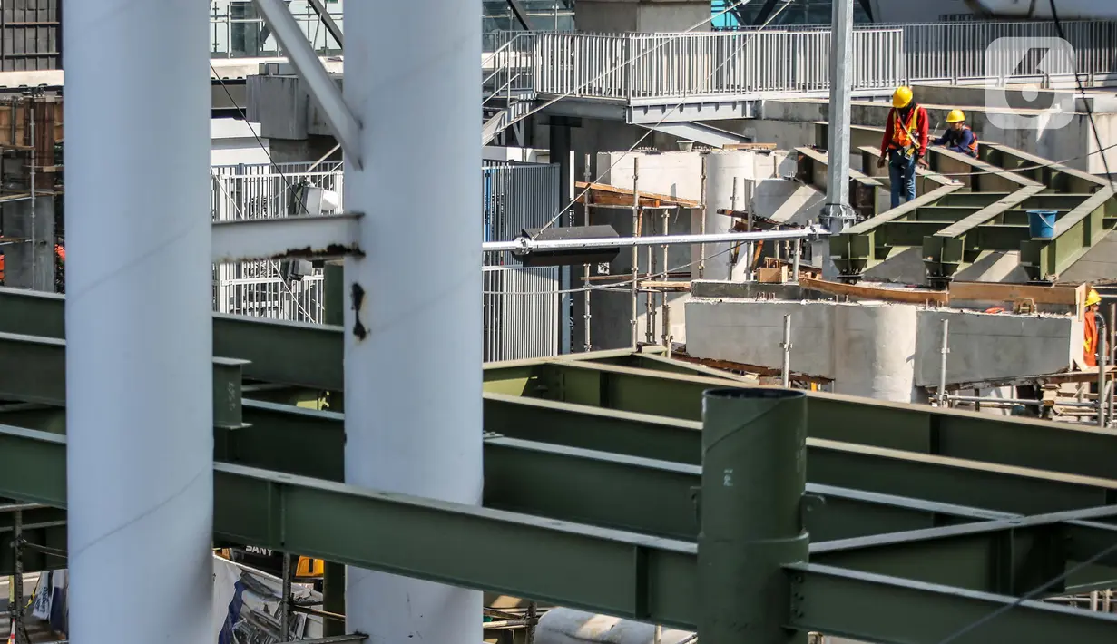 Aktivitas pekerja di area proyek pembangunan skybridge di simpang CSW, Jakarta Selatan, Senin (27/7/2020). Proyek yang akan mengintegrasikan Halte Transjakarta Koridor 1 (Blok M-Kota) dan Koridor (Ciledug-Mampang) dengan Stasiun MRT Asean ditargetkan rampung akhir 2020. (Liputan6.com/Faizal Fanani)