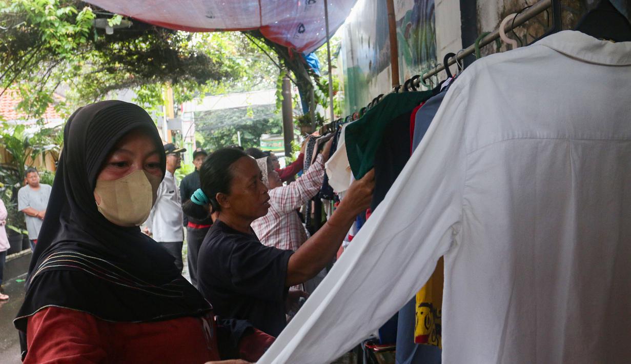 Kegiatan ini telah berlangsung selama sembilan tahun dan menjadi agenda rutin warga setiap Ramadan. Tampak dalam foto, warga memilih pakaian layak pakai yang dibagikan secara cuma-cuma di permukiman RT 02/RW 04 kawasan Jati Padang, Jakarta, Jumat (6/3/2026). (merdeka.com/Arie Basuki)