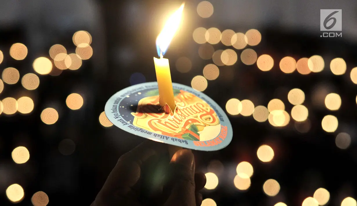 Sebuah lilin menyalan ketika jemaat memanjatkan doa di Gereja Immanuel, Jakarta, Senin (24/12). Misa Natal tahun ini mengangkat tema Membangun Spiritualitas Damai yang Menciptakan Perdamaian. (Merdeka.com/Iqbal S. Nugroho)