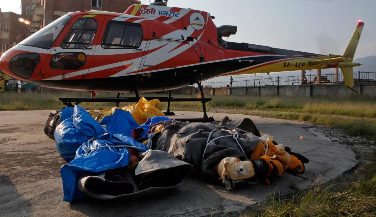 Jasad pendaki India yang tewas di  Everest diturunkan dari helikopter setibanya di ibu kota Nepal, Minggu (28/5). Jasad Ravi Kumar diterbangkan ke Kathmandu bersama dengan jasad dua orang lainnya yang meninggal tahun lalu. (AP Photo/Niranjan Shrestha)