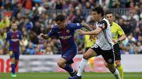 Gelandang Barcelona Philippe Coutinho (kiri) melewati penjagaan kapten Valencia, Dani Parejo, pada pertandingan di Camp Nou, Sabtu (14/4/2018). (AFP/Lluis Gene)
