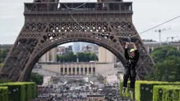Aksi seorang wanita menaiki flying fox dari Menara Eiffel di Paris, 5 Juni 2017. Kesempatan ini dibuka untuk umum jelang turnamen tenis French Open agar dapat merasakan bagaimana kecepatan bola tenis yang dipukul oleh petenis. (AP Photo/Kamil Zihnioglu)