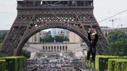 Aksi seorang wanita menaiki flying fox dari Menara Eiffel di Paris, 5 Juni 2017. Kesempatan ini dibuka untuk umum jelang turnamen tenis French Open agar dapat merasakan bagaimana kecepatan bola tenis yang dipukul oleh petenis. (AP Photo/Kamil Zihnioglu)