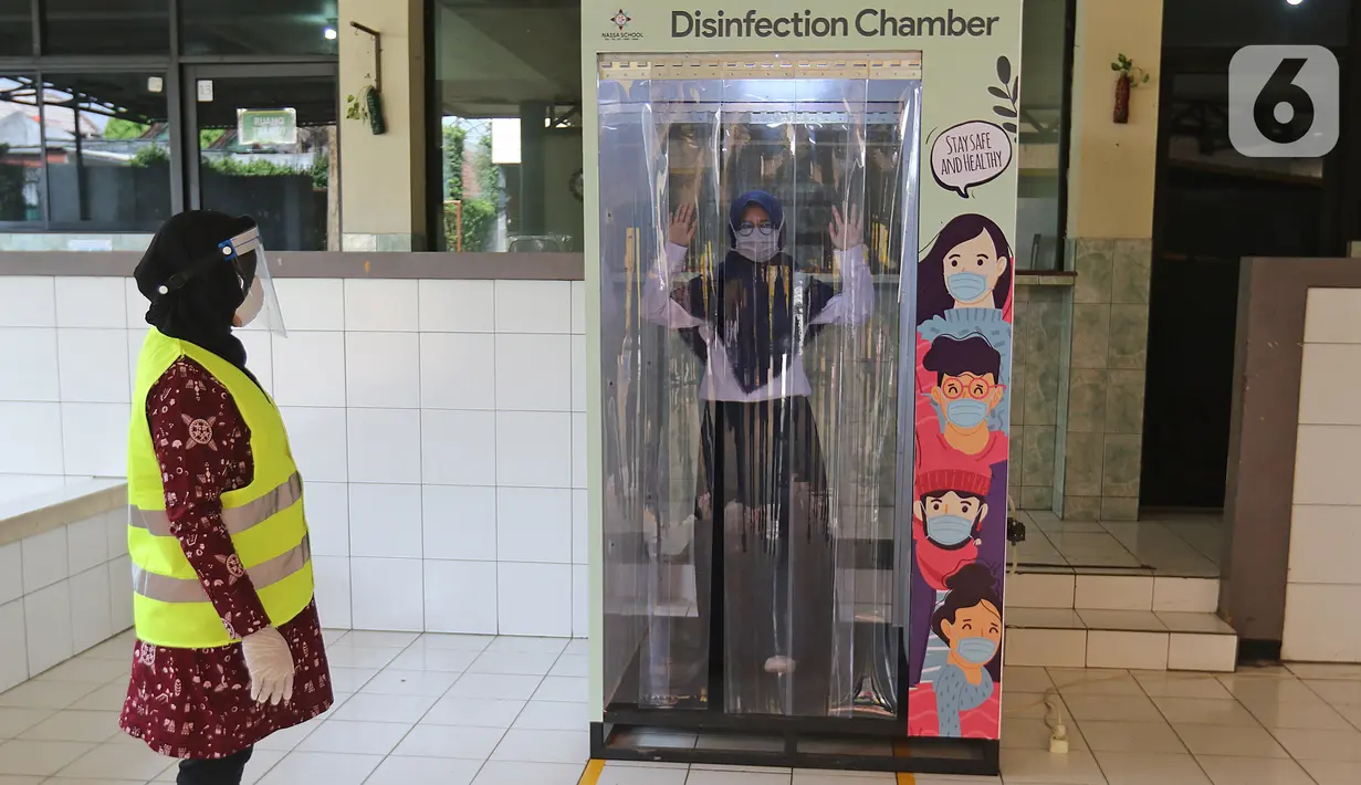 Siswa masuk bilik disinfektan di Sekolah Nasional Satu (Nassa School), Bekasi, Rabu (24/6/2020). Menuju kenormalan baru, Nassa School memberlakukan protokol kesehatan COVID-19 dengan membatasi jumlah siswa serta penggunaan teknologi ultraviolet guna membersihkan kelas. (Liputan6.com/Herman Zakharia)
