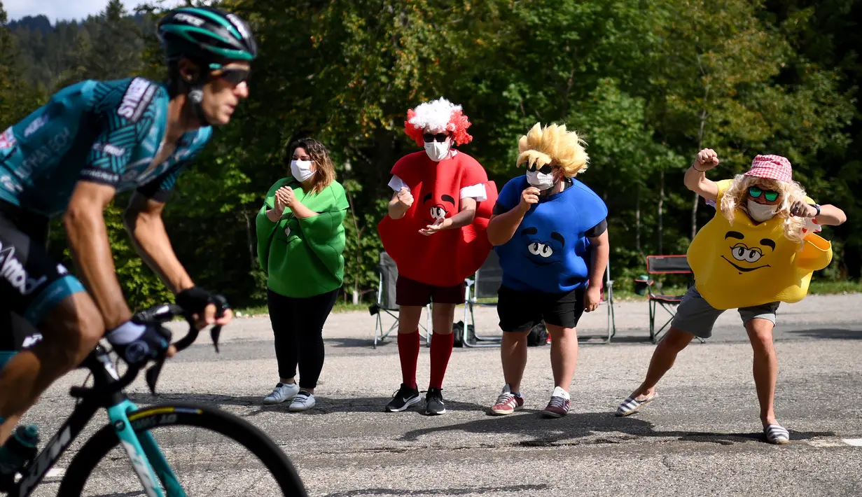 Sejumlah penonton berkostum unik memberikan semangat kepada pebalap sepeda pada ajang balap sepeda Tour de France di La Tour du Pin, Selasa (15/9/2020). (AFP/Marco Bertorello)