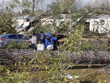 Teman dan keluarga berdoa di luar rumah mobil yang rusak di Flatwood, Alabama, Rabu (30/11/2022). Badai Tornado melanda daerah tersebut yang mengakibatkan dua orang tewas di komunitas Flatwood di utara kota Montgomer. (AP Photo/Butch Dill)