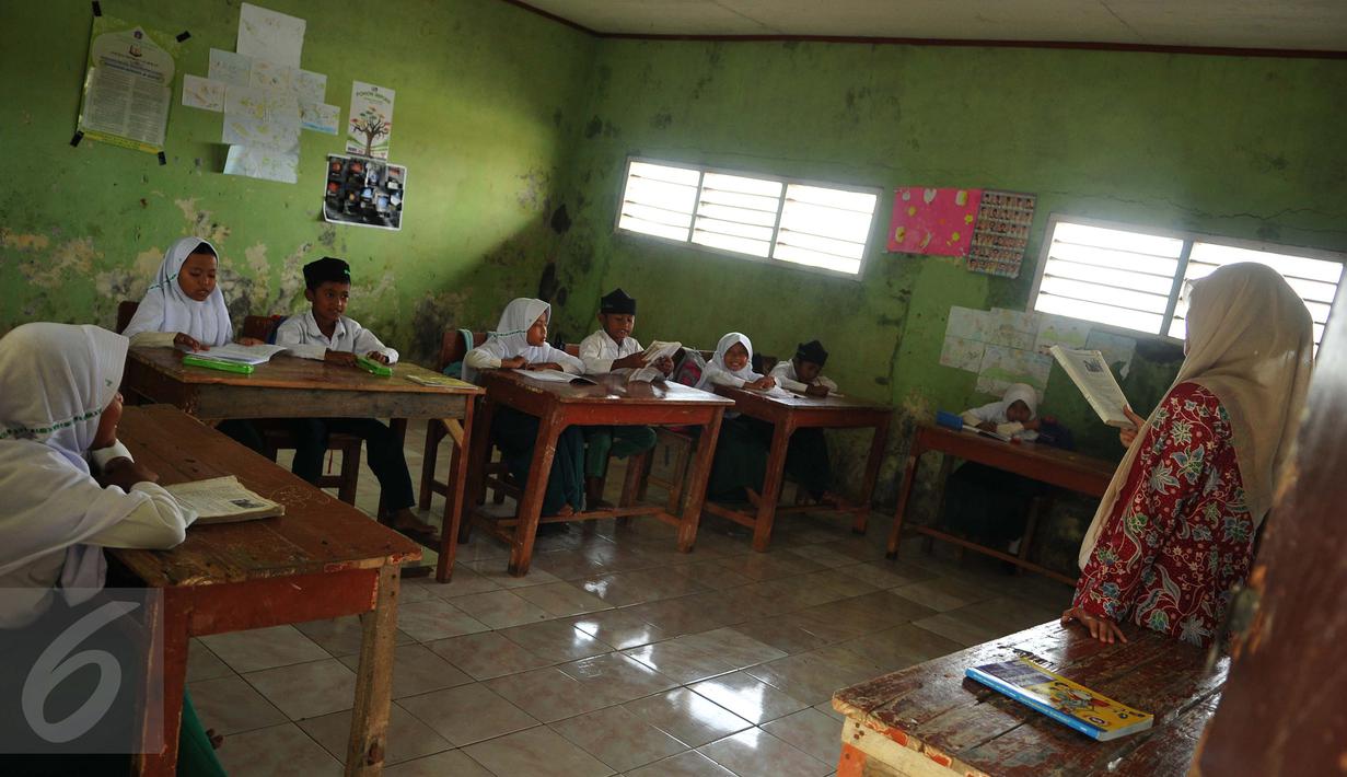 Suasana belajar mengajar di MI Mansyaul Huda yang terkena dampak abrasi di pantai Muara Gembong, Bekasi, Selasa, (26/7). Tingkat abrasi yang tinggi menyebabkan sejumlah rumah terkikis dan beberapa sekolah terendam air laut. (Liputan6.com/Gempur M Surya)