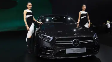 Dua model berpose di samping Mercedes Benz CLS 53 2019 selama Thailand International Motor Expo di Bangkok (29/11). Thailand International Motor Expo bertema “Enjoy Driving! Before Driverless Era”.  (AFP Photo/Lillian Suwanrumpha)