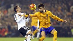 Striker Valencia, Paco Alcacer, berebut bola dengan bek Barcelona, Gerard Pique, pada laga La Liga Spanyol di Stadion Mestalla, Spanyol, Sabtu (5/12/2015). (EPA/Kai Foersterling)