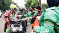 Mitra pengemudi Grab membagikan takjil kepada pengemudi ojek online dan penumpang dalam kegiatan Kolaborasi Kebaikan Mitra (KOLAK) di Surabaya. (Liputan6.com/HO)