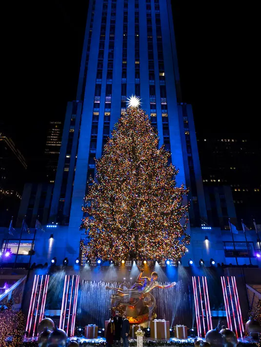 Lebih dari 50.000 lampu menghiasi Pohon Natal Rockefeller Center setinggi 75 kaki pada upacara tahunan pencahayaan di New York, Rabu (2/11/2020). Upacara yang digelar pada masa pandemi COVID-19 ini mewajibkan pengunjung untuk memakai masker, pembatasan waktu, dan jaga jarak. (AP Photo/Craig Ruttle)