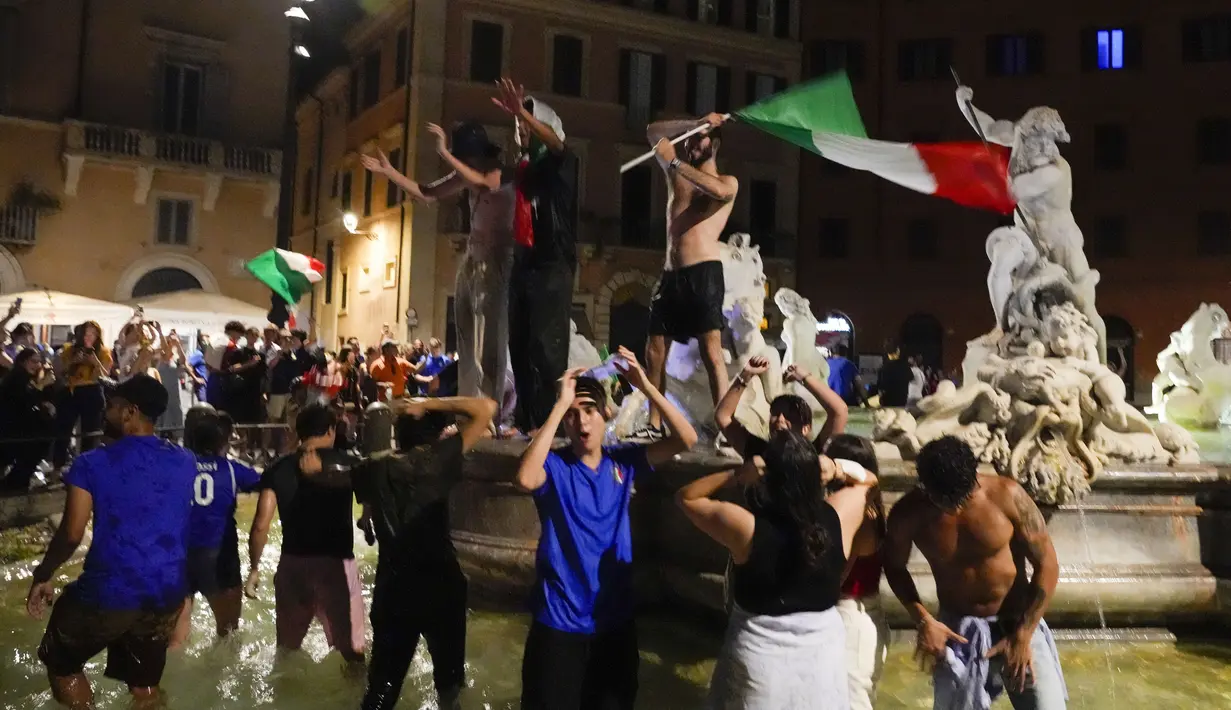 Suporter merayakan kemenangan Italia atas Inggris pada pertandingan final Euro 2020 di Roma, Italia, Senin (12/7/2021). Italia menjuarai Euro 2020 usai mengalahkan Inggris lewat drama adu penalti pada pertandingan final. (AP Photo/Gregorio Borgia)
