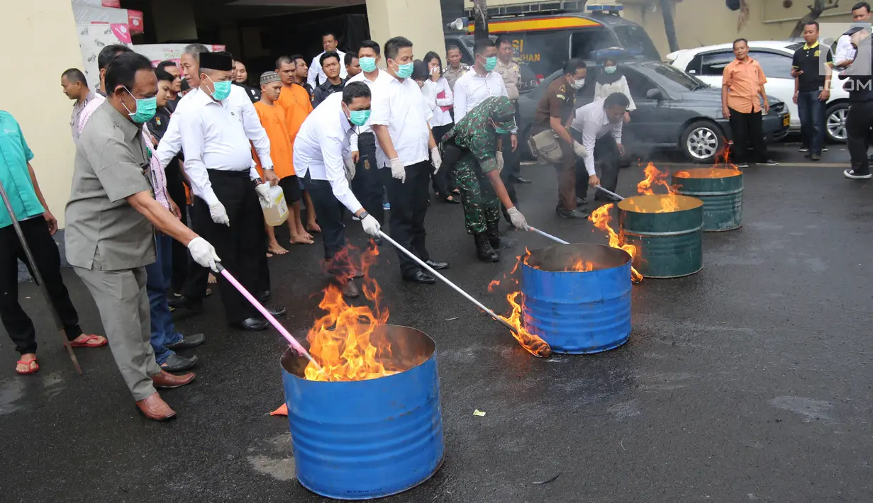 Petugas memusnahkan barang bukti narkoba berupa ganja dan sabu di halaman Polres Jakarta Utara, Senin (19/2). Polres Metro Jakarta Utara memusnahkan sebanyak 42 kg ganja. (Liputan6.com/Arya Manggala)