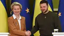 Presiden Ukraina Volodymyr Zelensky (kanan) dan Presiden Komisi Eropa Ursula von der Leyen berjabat tangan setelah konferensi pers bersama setelah pembicaraan di Kyiv, Kamis (2/2/2023). Kepala Komisi Eropa mengumumkan bahwa ia telah tiba di Kyiv dengan tim komisioner dan diplomat paling senior di blok tersebut, sehari sebelum KTT Ukraina-Uni Eropa di negara yang dilanda perang itu. (Sergei SUPINSKY/AFP)