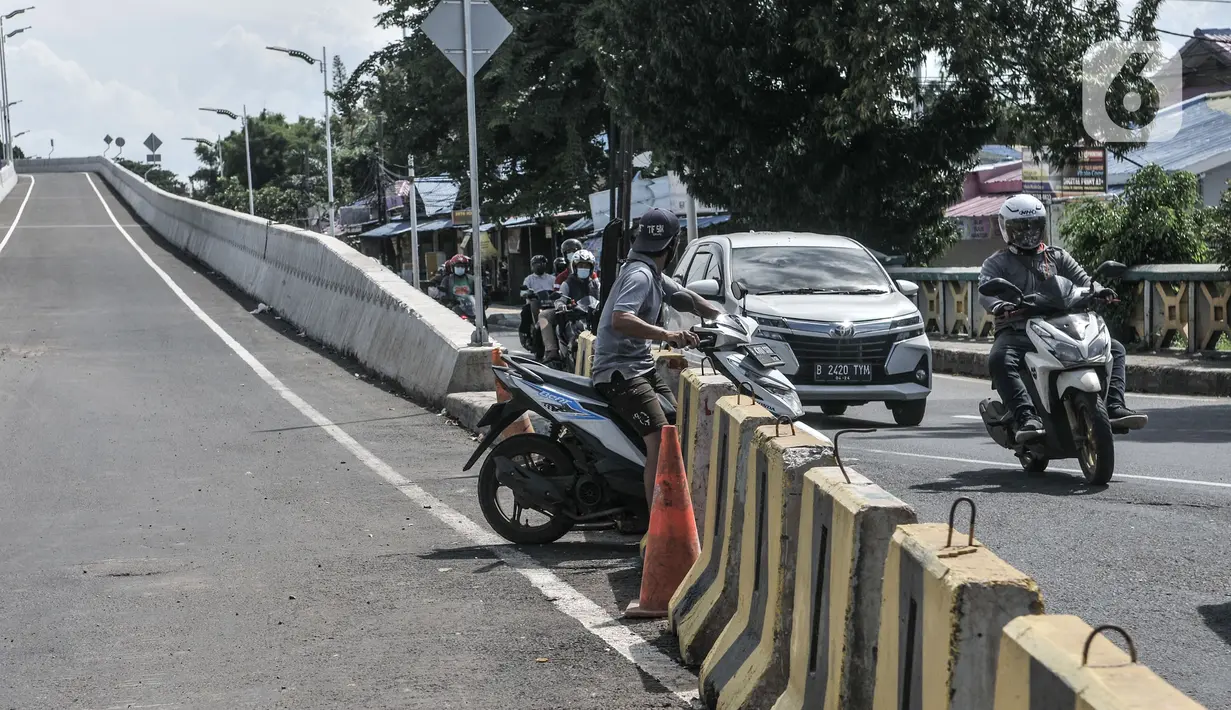 Pengendara motor menerobos separator yang menutup akses jalan layang atau flyover tapal kuda Lenteng Agung, Jakarta, Minggu (28/2/2021). Peristiwa ini dapat membahayakan pengendara sepeda motor karena aktivitas pembangunan flyover masih berlangsung. (merdeka.com/Iqbal S Nugroho)