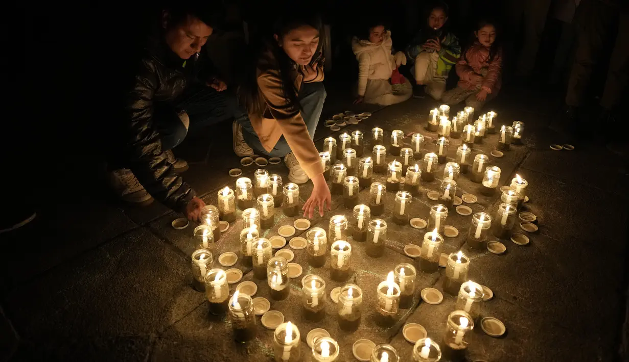 Orang-orang menggunakan lilin untuk membuat angka 60, yang mewakili menit dalam satu jam, saat memperingati Earth Hour di La Paz, Bolivia, Sabtu, 25 Maret 2023. Earth Hour berlangsung di seluruh dunia pada pukul 8:30 malam waktu setempat dan merupakan seruan global untuk mematikan lampu selama 60 menit, sebagai tindakan simbolis untuk meningkatkan kesadaran tentang perubahan iklim. (AP Photo/Juan Karita)