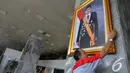 Petugas memasang foto Presiden Jokowi di pilar Gedung Nusantara III Kompleks Parlemen Senayan, Selasa (23/12/2014). (Liputan6.com/Andrian M Tunay)