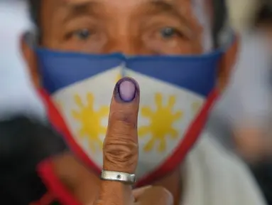 Raul Bragais, 64, menunjukkan jari yang telah dicelup tinta usai menggunakan hak pilihnya pada Pemilu Filipina di Quezon City, Senin (9/5/2022). Warga Filipina mulai memberikan suara untuk memilih presiden baru pada hari Senin, dengan putra mantan diktator yang digulingkan menjadi pesaing terkuat seorang pejuang reformasi dan hak asasi manusia. (AP Photo/Aaron Favila)
