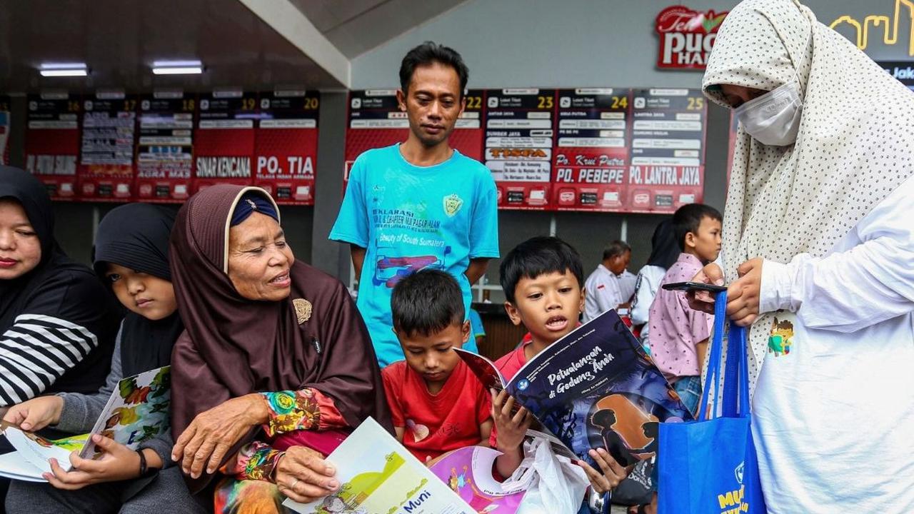 Badan Bahasa Kementerian Pendidikan, Kebudayaan, Riset, dan Teknologi (Kemendikbudristek)  membagikan buku bacaan cerita gratis untuk anak-anak pemudik di Terminal Kalideres, Jakarta Barat, Selasa (2/4/2024). Foto: Liputan6.com / Angga Yuniar