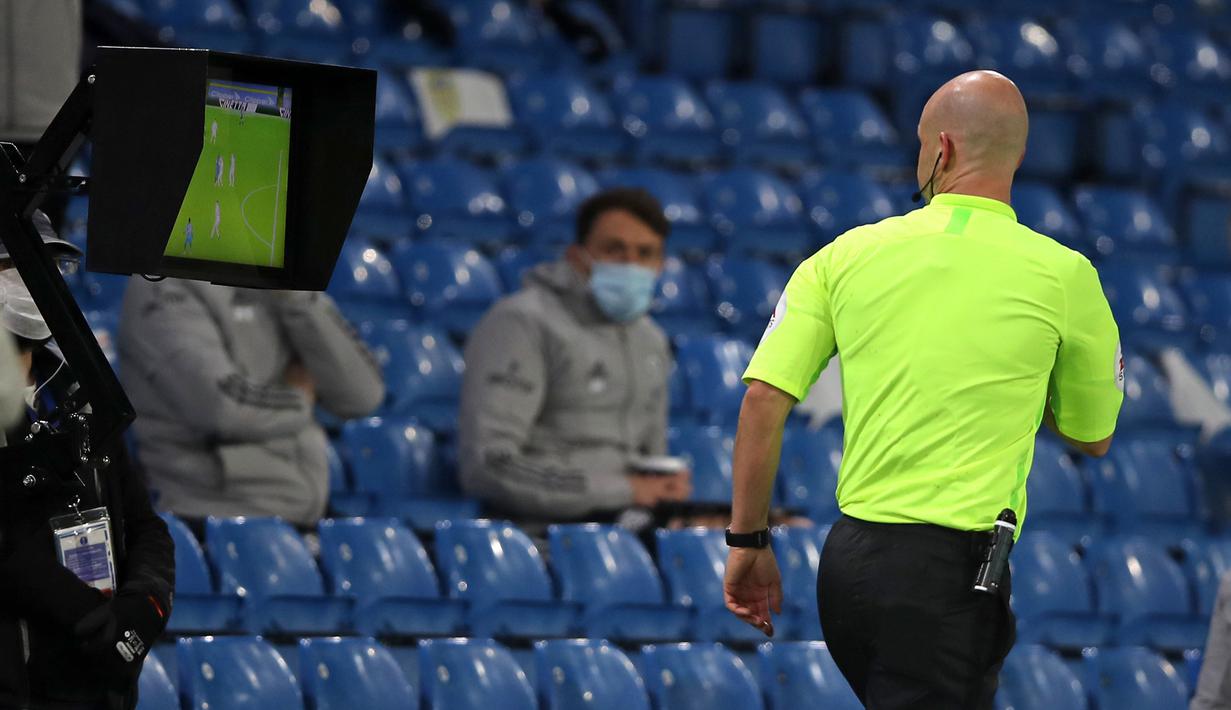 Wasit Anthony Taylor memeriksa VAR yang memutuskan memberi kartu merah kepada gelandang Arsenal, Nicolas Pepe, dalam laga lanjutan Liga Inggris pekan ke-9 di Elland Road Stadium, Leeds, Minggu (22/11/2020). Arsenal bermain imbang 0-0 dengan Leeds United (AFP/Molly Darlington/Pool)