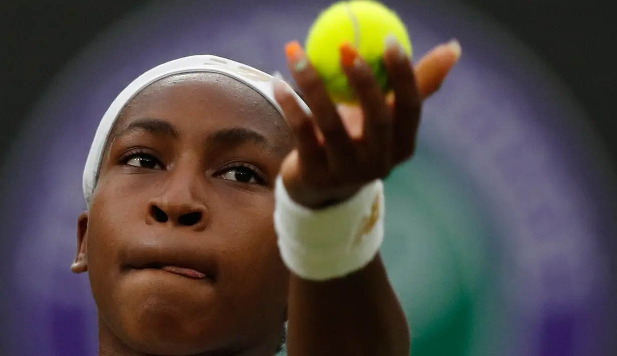 Petenis AS, Cori Gauff melakukan servis ke petenis Slovakia, Magdalena Rybarikova pada babak kedua Wimbledon di All England Lawn Tennis Club, London, Rabu (3/7/2019). Petenis muda AS berusia 15 tahun itu melaju ke babak ketiga setelah menaklukkan, Magdalena Rybarikova 6-3, 6-3. (Adrian DENNIS/AFP)