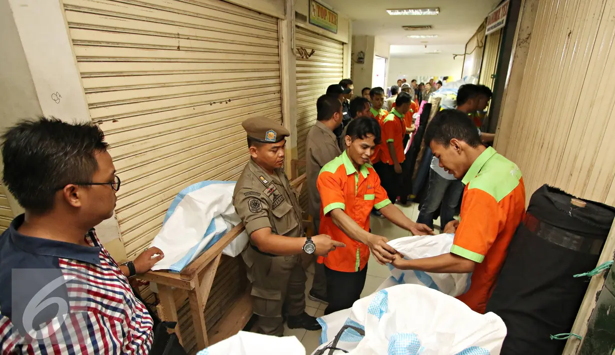 Petugas Satpol PP memantau pengosongan kios di Pasar Blok F Tanah Abang, Jakarta, Rabu (4/5). Pengosongan dilakukan karena pemilik kios tidak membayar kewajiban PHP yang berakhir sejak 2012. (Liputan6.com/Immanuel Antonius)