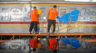 Seniman mural dan grafiti menggambar pada gerbong Kereta Rangkaian Listrik (KRL) Edukasi di Depo KRL, Depok, Jawa Barat, Kamis (29/8/2024). (merdeka.com/Arie Basuki)