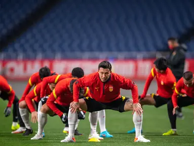 Para pemain China melakukan pemanasan saat mengikuti sesi latihan di Stadion Saitama, Jepang, Rabu (26/1/2022). China akan menghadapi Jepang pada Kualifikasi Piala Dunia 2022 Grup B Zona AFC. (AFP/Philip Fong)