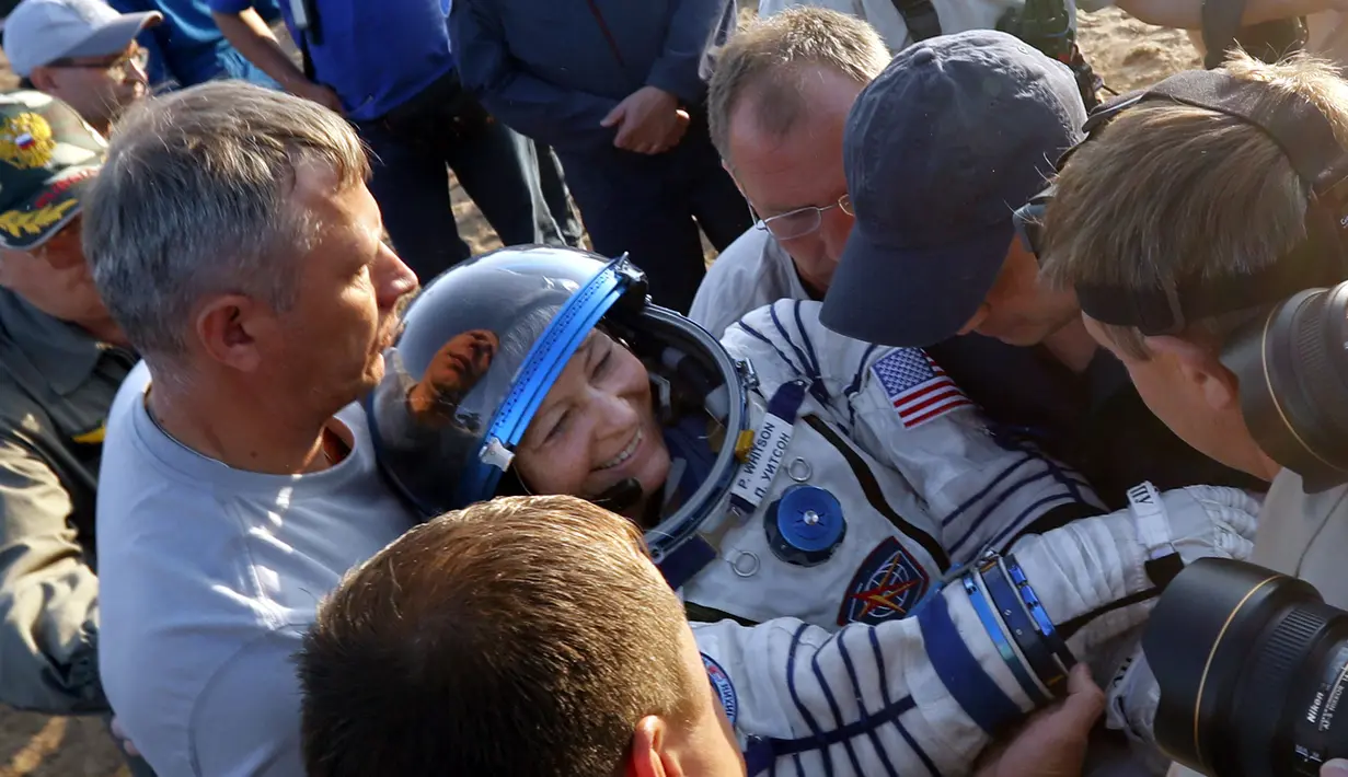 Peggy Annette Whitson mendapat bantuan saat hendak  keluar dari kapsul Soyuz MS-04 di daerah terpencil luar kota Dzhezkazgan, Kazakhstan, Minggu (3/9). Whitson mencetak rekor sebagai astronaut AS dengan misi terlama di ISS (Sergei Ilnitsky/Pool via AP)
